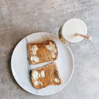 two slices of toast and a glass of milk on a plate