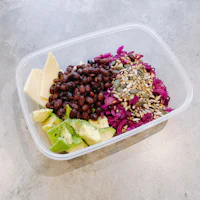 a plastic container with black beans, red cabbage and avocado