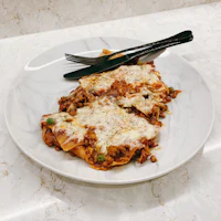 a plate of lasagna with a fork on it
