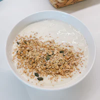 a bowl of yogurt with granola and seeds