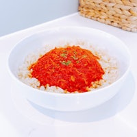 a bowl filled with rice and tomato sauce