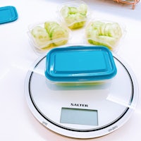 a scale with cucumbers and containers on it