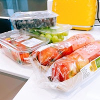 a bunch of fruit in plastic containers on a counter