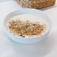 a bowl of granola with a basket next to it