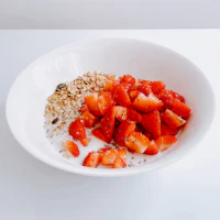 strawberries and granola in a white bowl