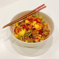 a bowl of food with chopsticks in it