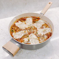 a pizza in a pan with a wooden spatula