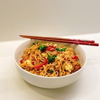 a bowl of noodles with chopsticks in it