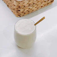 a glass of milk with a straw and a basket next to it