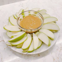 sliced apples with peanut butter on a plate