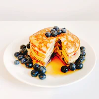 a stack of pancakes with blueberries on a plate