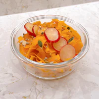 a bowl filled with carrots and radishes