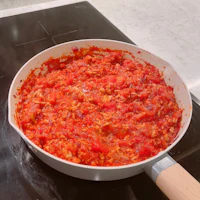 a pan full of red sauce on a stove top