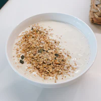 a bowl of yogurt with granola and seeds